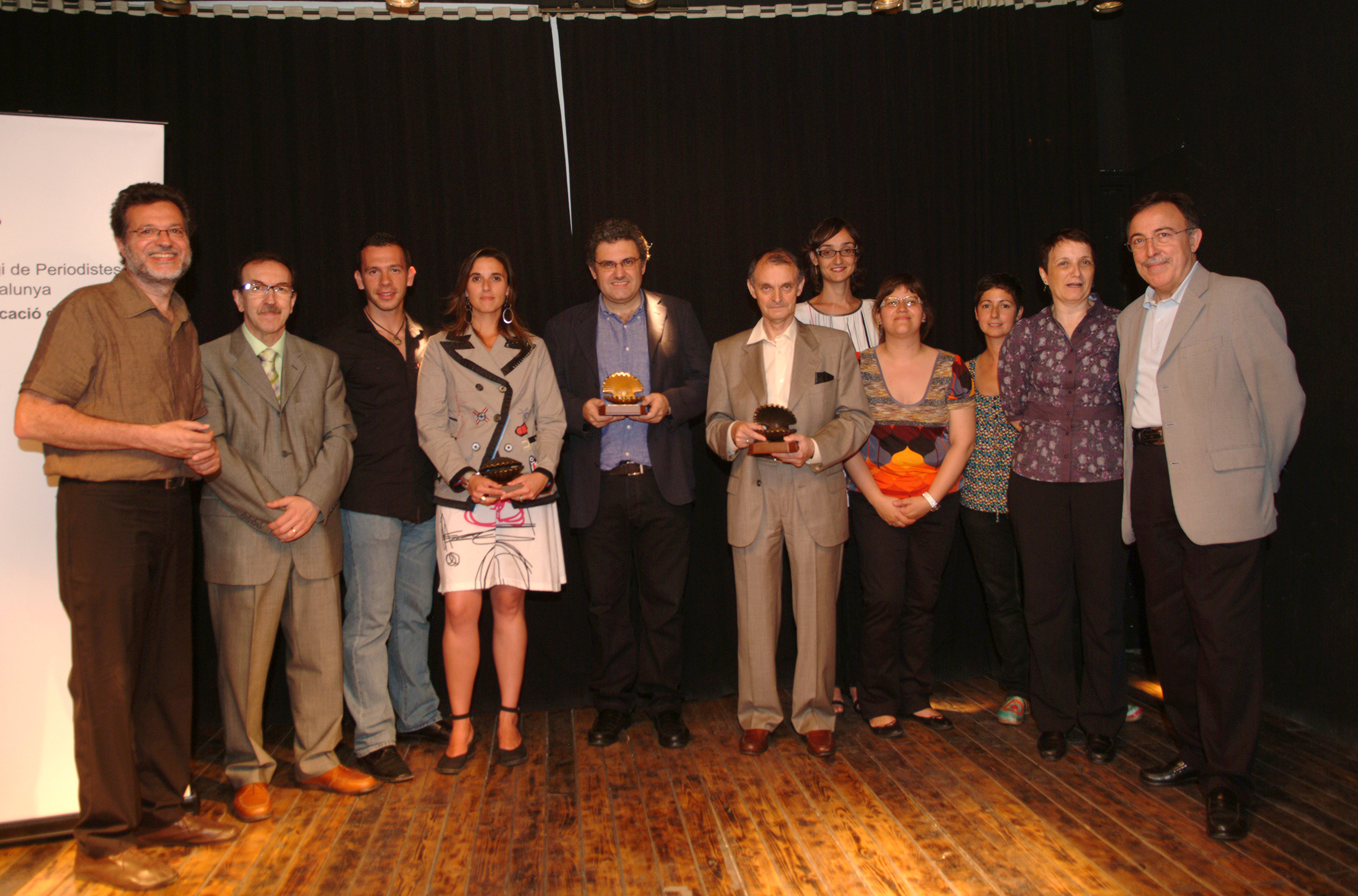 Lliurament Petxines 2009 amb el president de l'Audiència, Antonio Carril (oberta), el periodista Xavier Bas (daurada) i l'oficina de comunicació dels Mossos (tancada), acompanyats dels finalistes