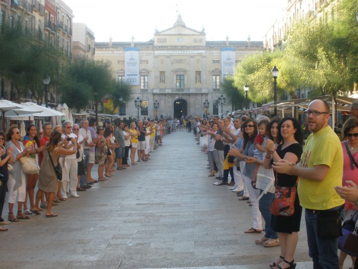 Moment de la cadena humana a la plaça de la Font, amb participants a banda i banda de l'itinerari.