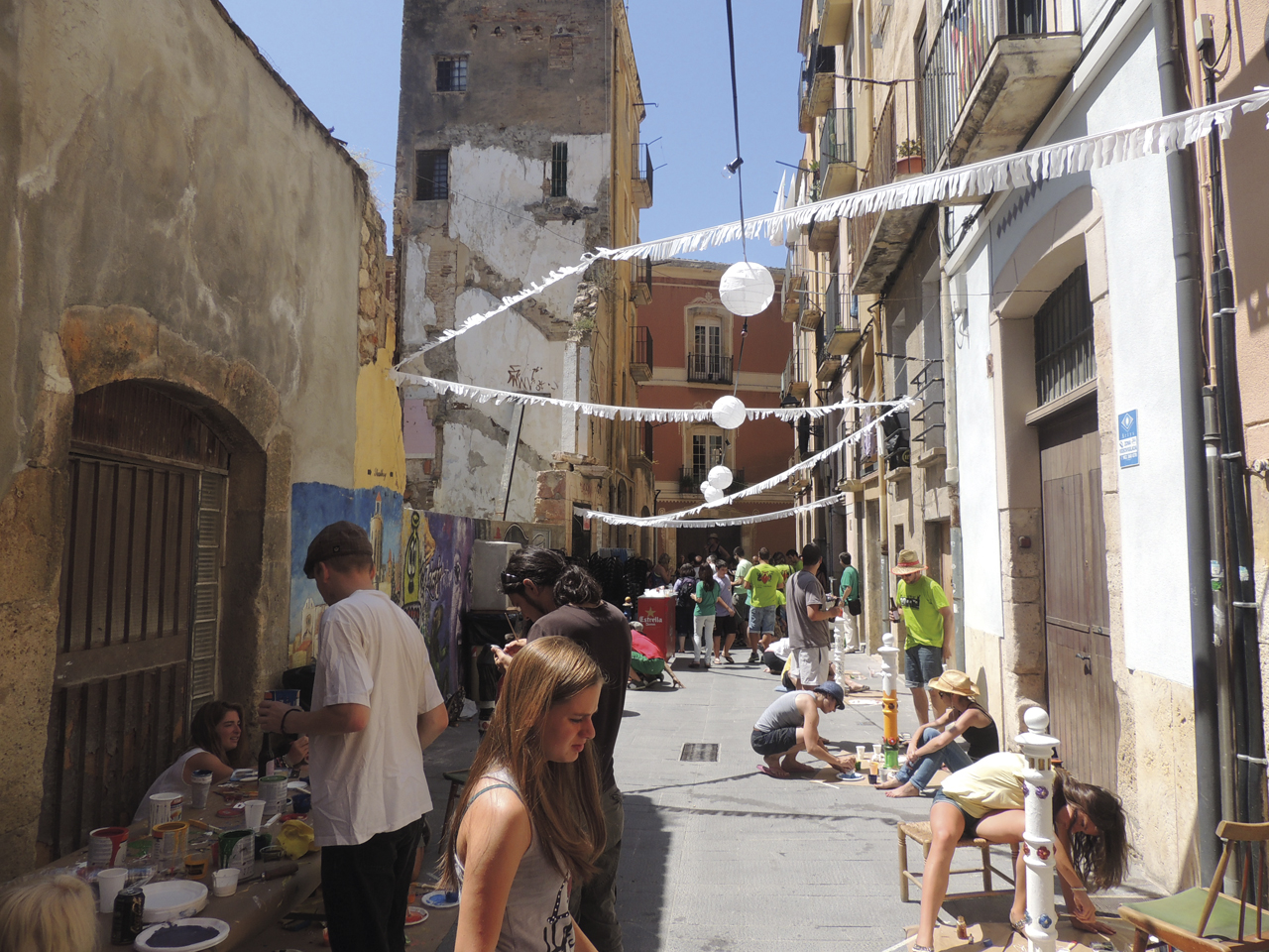 Imatge del carrer mentre la gent pinta els pilons.