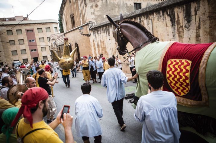 Els membres de l'Àliga i la Mulassa s'intercanvien els elements al carrer de Sant Pau, abans de l'inici de la Professó de Santa Tecla. Foto: DAVID OLIETE 