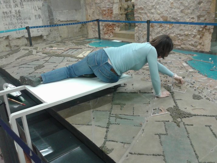 Una conservadora neteja des d'una plataforma la maqueta de la Tàrraco romana. Foto: RICARD LAHOZ 